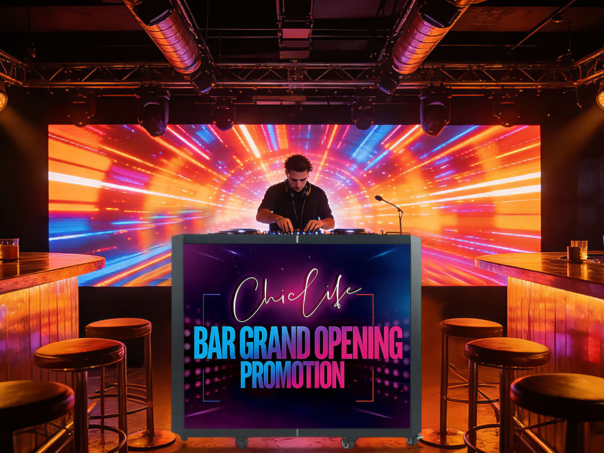 DJ performing behind an LED DJ booth at a bar grand opening